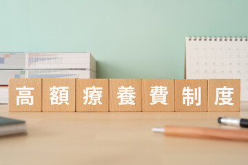 高額療養費制度と書かれたブロックが置かれたデスク