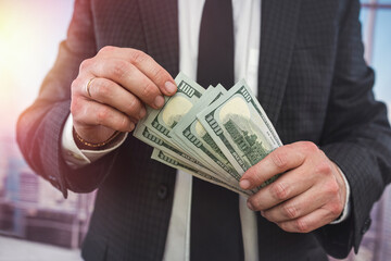 close up business man in classik black siut hold and check dollar