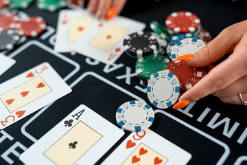 dealer's hands are holding stacks of poker chips and play card, risk for win