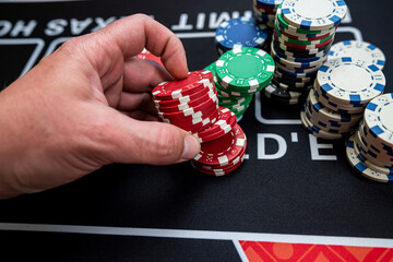  close up of mans hand makes puts a chips and make bet, casino