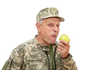 Portrait of old defender isolated on white background. Soldier eats green apple and smiling to the...