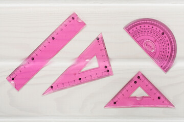 Set of transparent rulers on wooden backgroung, top view