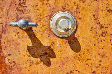 Antique, unique, orange rusting abstract car part, two silver shapes, cross, crucifix shadow