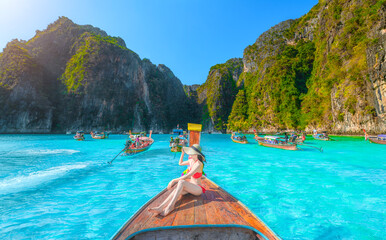 Traveler woman joy fun relaxing on boat at Pileh Lagoon Bay, Phi Phi Island, Krabi, Tourist girl on summer holiday vacation trip, beautiful place, crystal clear emerald waters. - obrazy, fototapety, plakaty