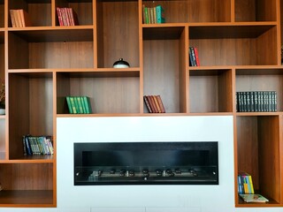 Wall with bookshelves with books and fireplace.Modern interior background