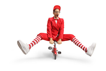 Funny man in a red suit riding a small red bike