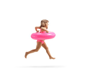 Full length profile shot of a girl in swimsuit running with a pink rubber swimming ring