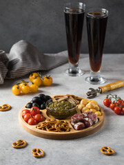 Wooden menagerie with beer snacks. A plate with assorted sausages, cheese, crackers.