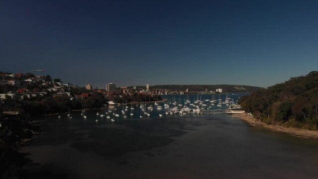 Aerial lift-off views capture Balgowlah Bay with Boats, yachts, beaches and buildings. Perfect for Real estate or Travel or Tourism. Experience the charm of this coastal city in 4k