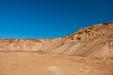 sand pit against the blue sky, forest in the background