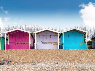 Obraz na płótnie Canvas Beach huts pink purple blue