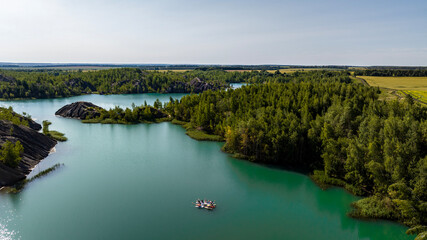 panoramic view of the high hills of the lake with turquoise water and green forest from the reserve in the Tula region taken from a drone