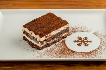 Tiramisu served with chocolate on a white porcelain plate