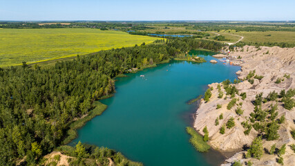 Obraz premium panoramic view of the high hills of the lake with turquoise water and green forest from the reserve in the Tula region taken from a drone