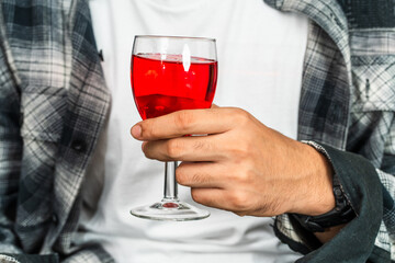 Embrace the allure of wine as a young man exhibits his drink with confidence and sophistication