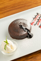 Chocolate souffle with flowing chocolate on a white porcelain plate