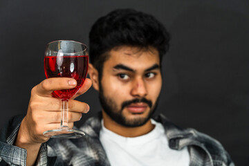 Discover the artistry of wine enjoyment as a young man shows off his drink in this enticing image