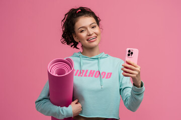 smiling happy beautiful woman in stylish sports outfit posing on pink background isolated in studio