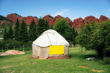 White yurts stand at the foot of the mountain. Mountain gorge Jety Oguz. Kyrgyzstan's picturesque...