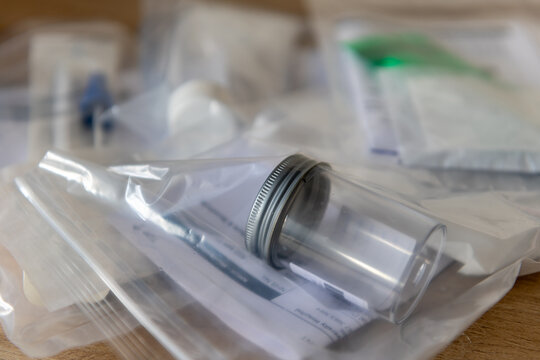 A pile of sample containers and request forms for medical test.