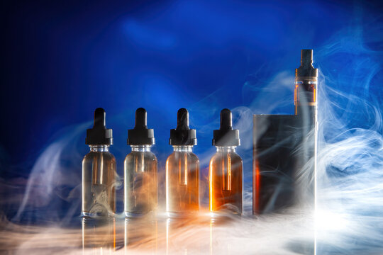 Electronic cigarette. Vape gadget. Vaping kit. Vaping pen. Oils for smoking vape. Liquids for vape gadget. Electronic cigarette on table. Vaping kit for smoking vapor. Refill juice e-cig