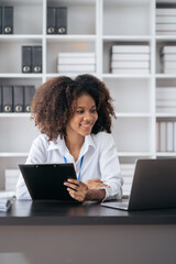 Businesswomen hand working with tablet and laptop computer with documents on office desk in modern office.