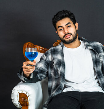 The young man's appreciation for his wine drink is artfully portrayed in this captivating image