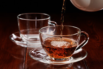 Tea is poured into a glass cup. Selective focus.
