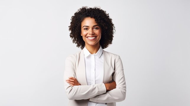businesswoman standing with arms crossed on a white background and looking at the camera.