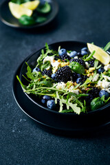 Berry  (blackberry, blueberry) and arugula salad with feta, pistachios and basil. Close-up - 626847541