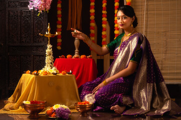 Portrait of Young Indian woman celebrating Indian festival in traditional way. Diwali Festival...
