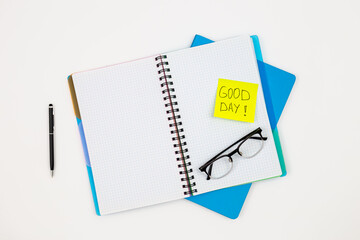 Notepad, glasses and pen on a white background, top view.