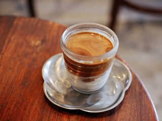 coffee latte with brown upper layer coffee and white lower layer fresh milk in glass on white background.