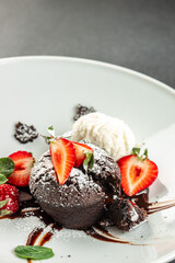 Chocolate fondant lava cake with strawberries, traditional french chocolate cake with liquid filling