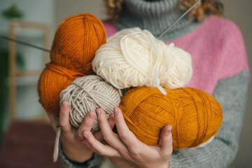 Woman hands with knitted toys, balls of thread and knitting needles, workplace. Concept-knitting, hobby and handicraft