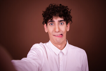 Young funny guy with different emotions posing on a brown background.