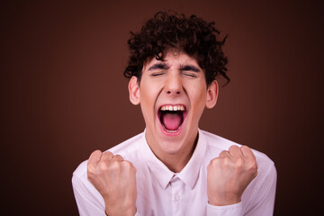 Young funny guy with different emotions posing on a brown background.