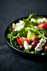 Mediterranean-style salad of cherry tomato, cucumber, arugula, feta cheese and smoked Kalamata olives