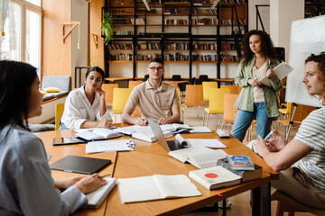 Group of students having discussion during presentation in library