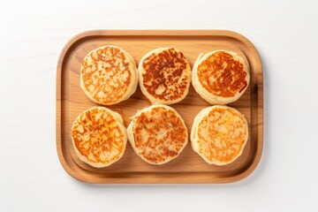 Fototapeta na wymiar Top View, Crumpets On A Wooden Boardon White Background. Crumpetmaking, Woodworking, Top View Photography, Food Presentation, White Backgrounds, Breakfast Foods. Generative AI