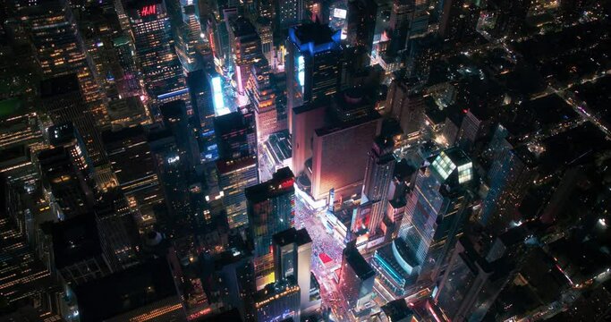 Helicopter Night Tour of New York City Architecture. Fly-By Over Glowing Times Square with Colorful Advertising Billboards and Groups of Tourists Enjoying Manhattan Nightlife and Admiring the Landmark
