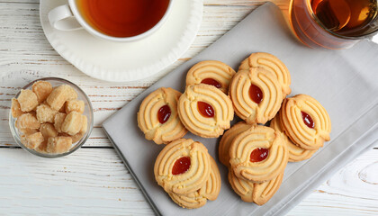 Delicious Danish butter cookies and tea on white wooden table, flat lay
