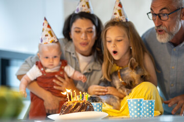 Family blowing birthday candles and celebrating