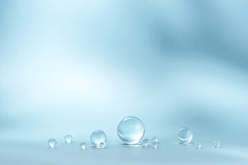 Blue background with transparent glass balls. Minimal concept and hard sunlight.