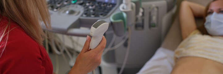 The doctor makes an ultrasound of the abdomen to woman