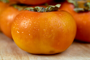 Ripe orange persimmon covered with drops