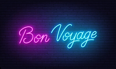 Bon Voyage neon lettering on brick wall background.