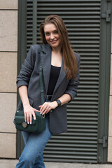 Portrait of a happy smiling woman in casual clothes while walking around the city.