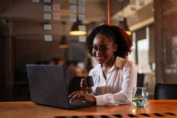 Black businesswoman working on laptop. Portrait of beautiful businesswoman in the office..