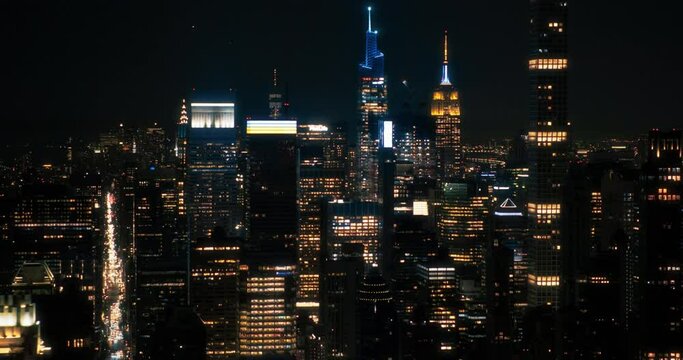 Aerial View of Midtown Manhattan Architecture at Night. Evening Footage of Financial Business District from a Helicopter. Scenery of Historic Office Towers, Including Illuminated Empire State Building